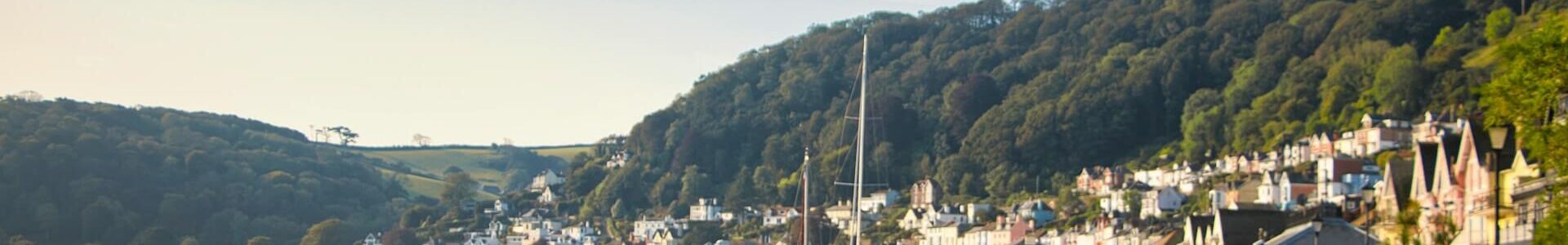 Busy Dartmouth dock with numerous boats and maritime activity, showcasing the historic English seaside town's important fishing and leisure port